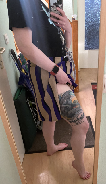 A view from teh side. The overlapping flaps of the wrap pants are pulled apart to show a Godzilla Tattoo. A view from teh side. The overlapping flaps of the wrap pants are pulled apart to show a Godzilla Tattoo.