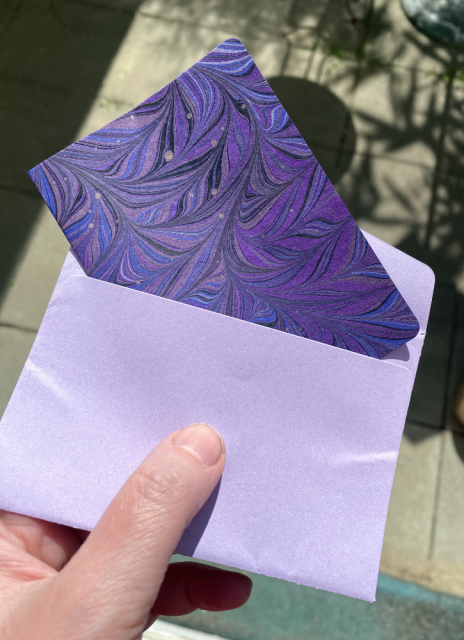 The envelope has been freed and opened, a folded sheet of marbled paper pokes out of it. The envelope has been freed and opened, a folded sheet of marbled paper pokes out of it.