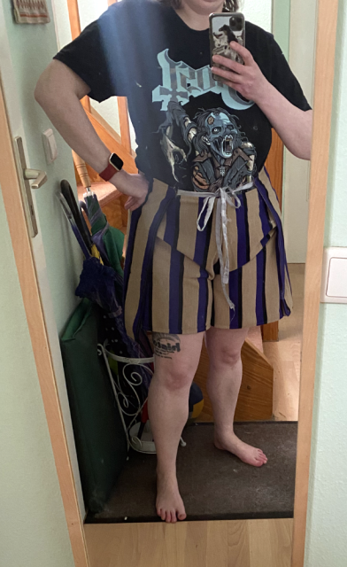 The t-shirt is now tugged into the trousers to show the front knot done with a silvery fabric. If one were to scroll in, they'd see the sewing and raggedy edges because the seamstress couldn't be bothered to do the inside-out pulling thing. The t-shirt is now tugged into the trousers to show the front knot done with a silvery fabric. If one were to scroll in, they'd see the sewing and raggedy edges because the seamstress couldn't be bothered to do the inside-out pulling thing.