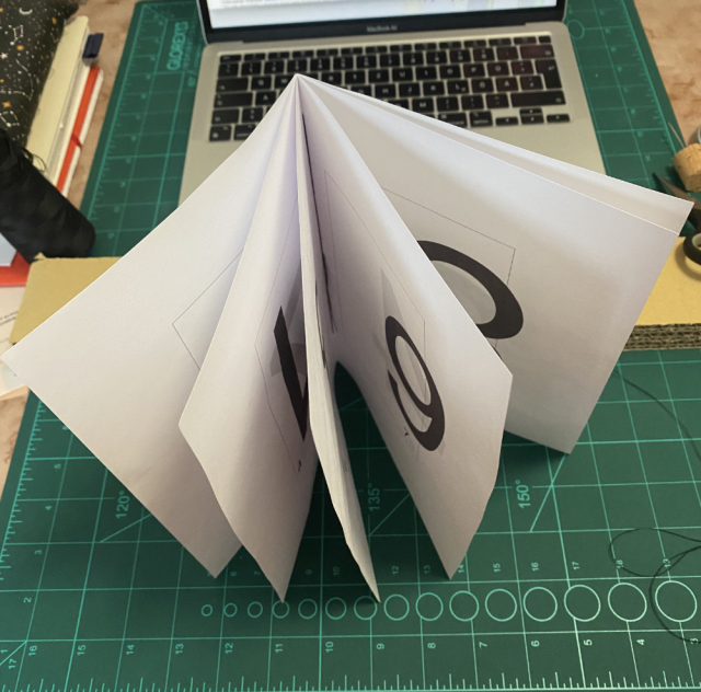 A booklet, 12-pages, handsewn. Standing upright and open, random numbers are visible on the pages. A booklet, 12-pages, handsewn. Standing upright and open, random numbers are visible on the pages.