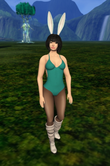 Self-portrait in a bunny outfit, consisting of white and cyan bunny ears, a teal one-piece bathing-suit, black sheer tights and white boots with integrated white leg warmers. My eye shadow and my nail polish are teal, too. The blurry background shows a part of By Numbers in Alternate Metaverse, a tree sculpture with an Easter egg on its roots and a mountain range.